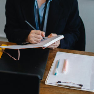 Professional woman writing on a notepad.